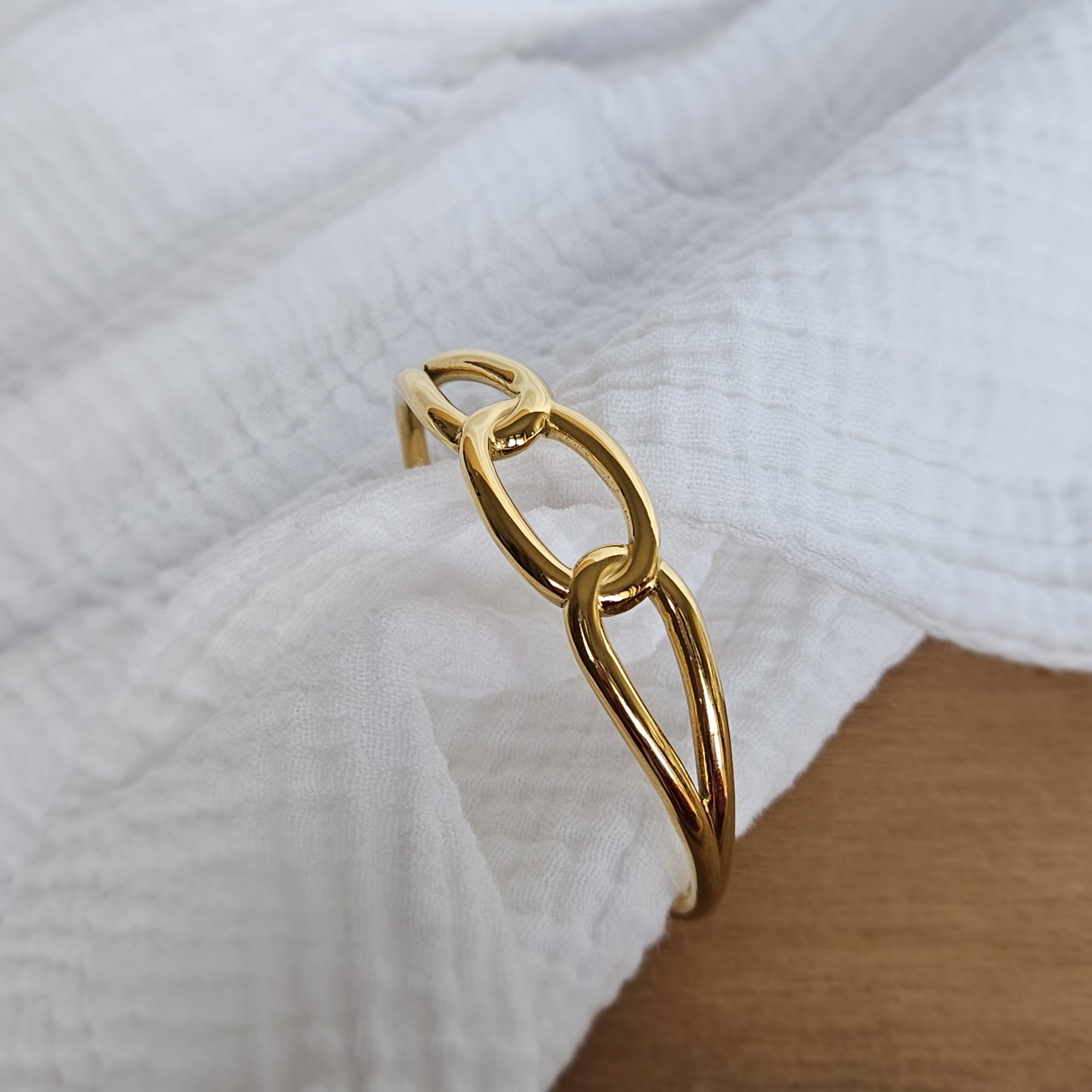 Jonc rigide à effet maillons doré.