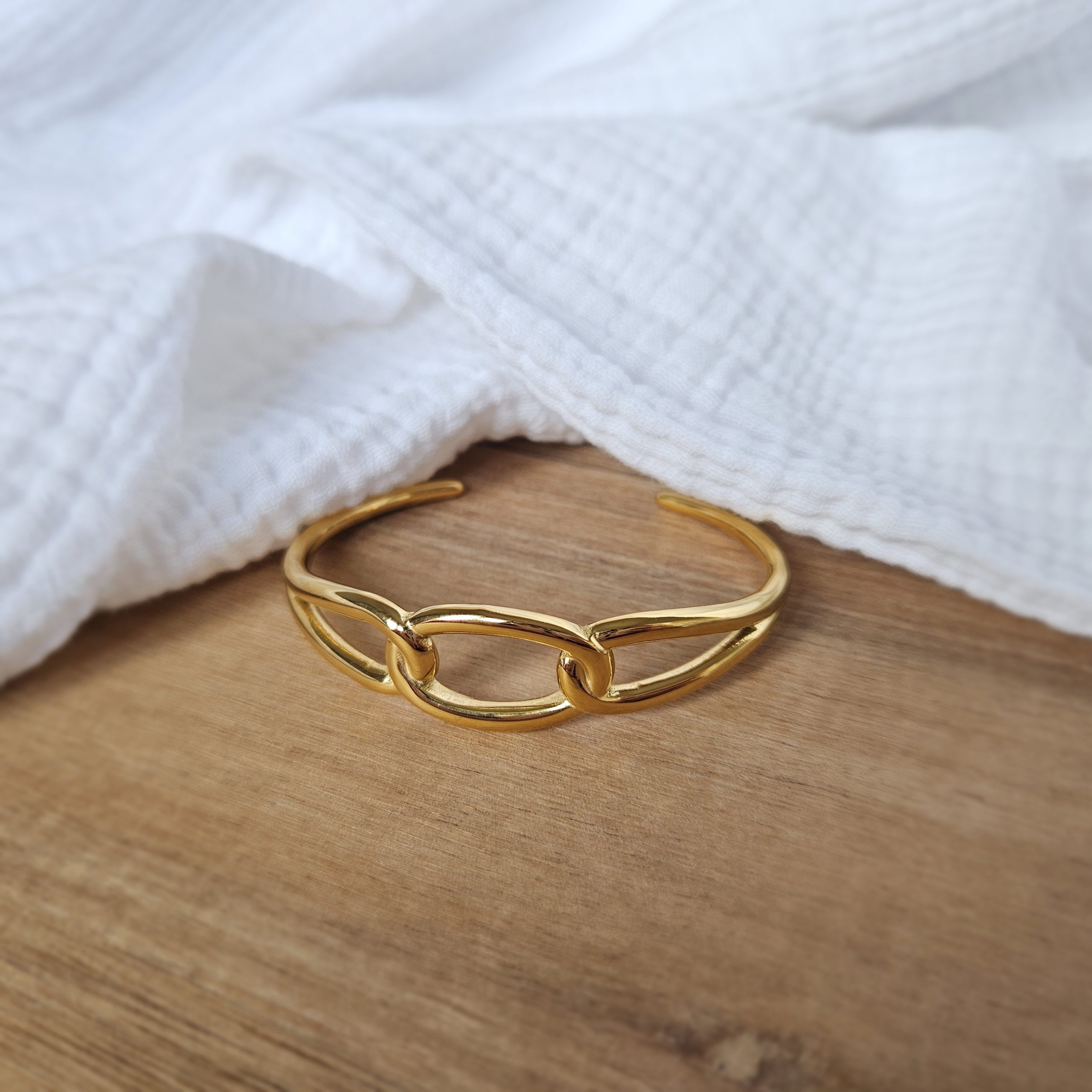 Jonc rigide à effet maillons doré.