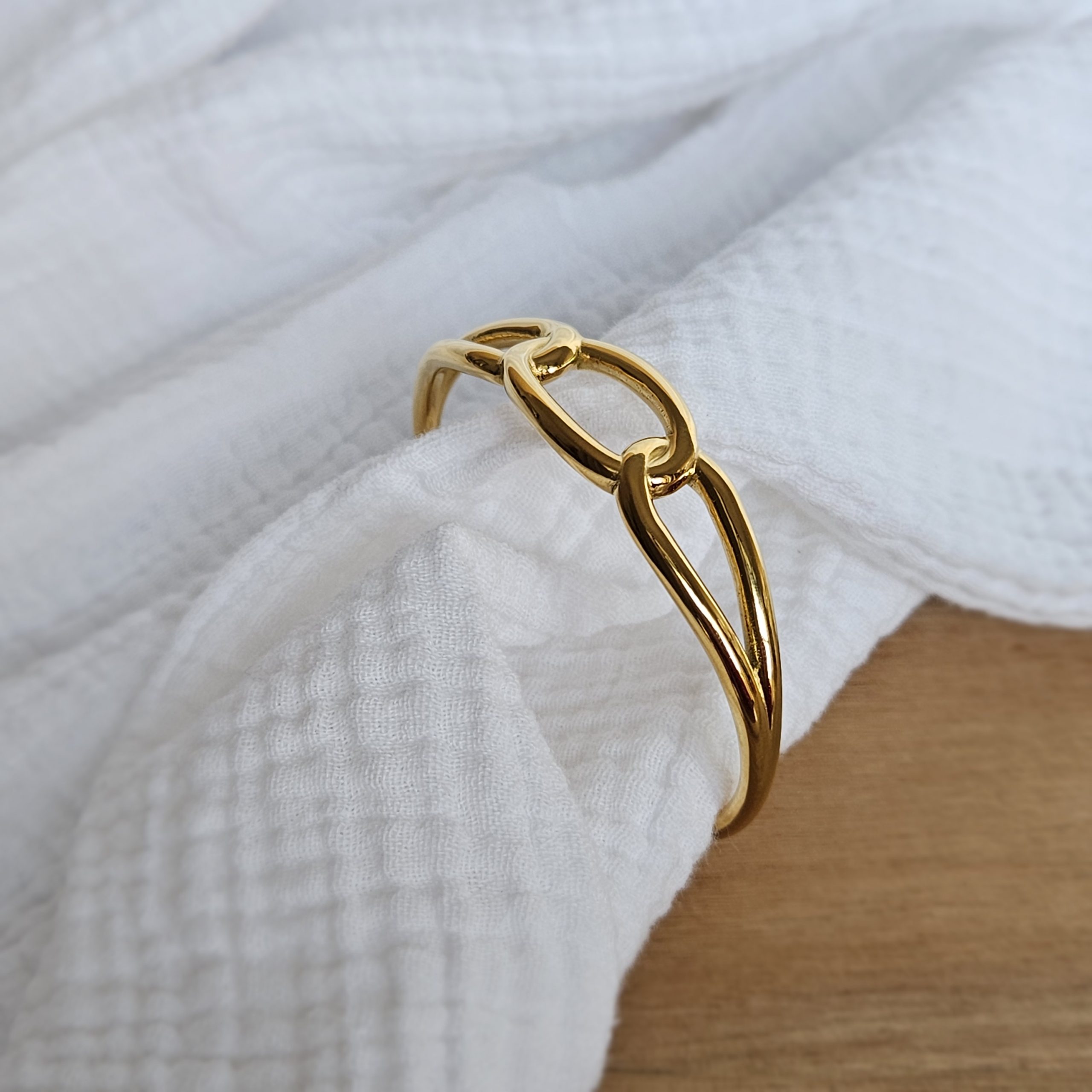 Jonc rigide à effet maillons doré.