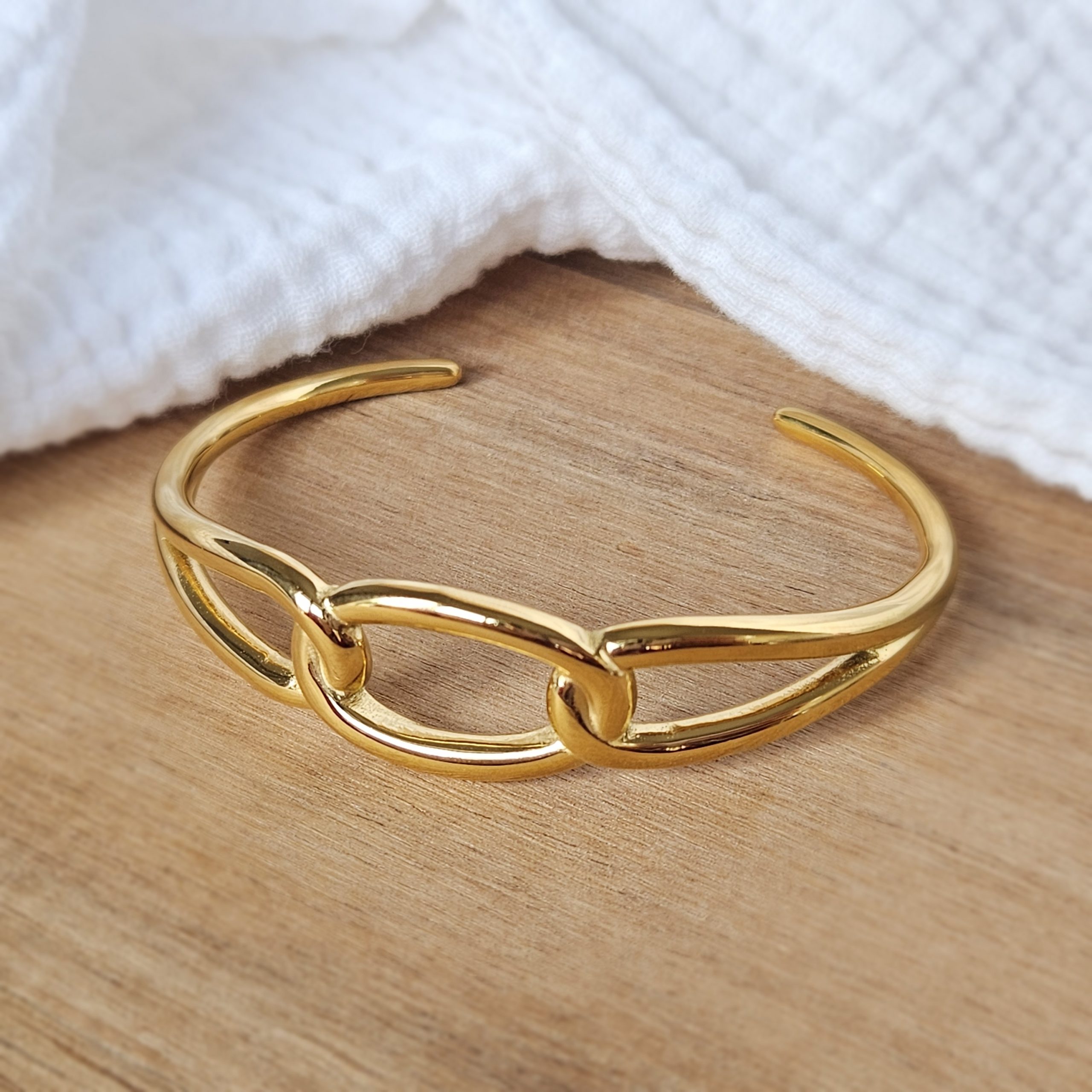 Jonc rigide à effet maillons doré.